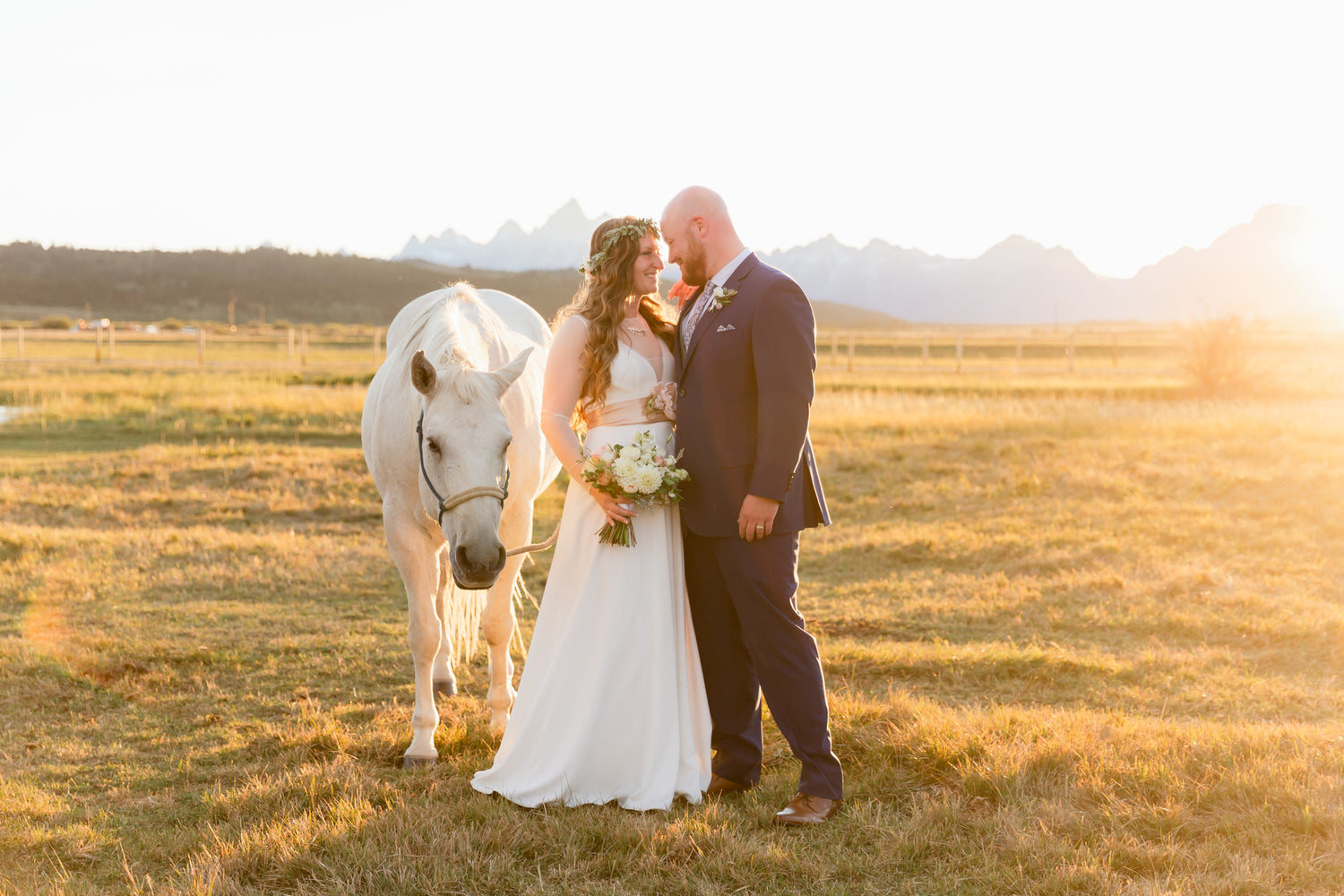 Sunset at Diamond Cross Ranch wedding with view of Teton mountains and white horse. Dandelion Floral.